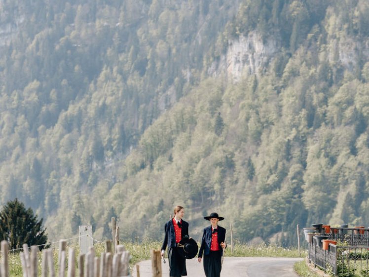 Ein Mann und eine Frau, die auf einer Straße mit Bergen im Hintergrund gehen